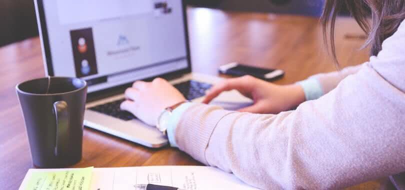A student typing at their laptop.
