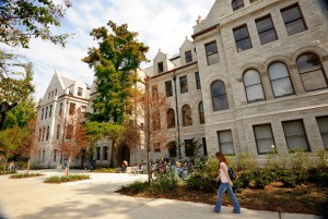 Student walking in front of a building at Tulane University's campus.