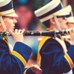 Students in a marching band lined up, holding their instruments.