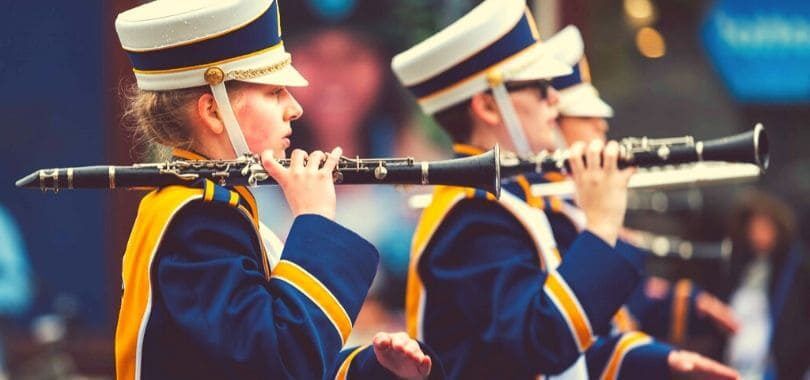 Students in a marching band lined up, holding their instruments.