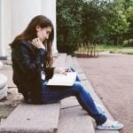 A student sitting and reading a book.