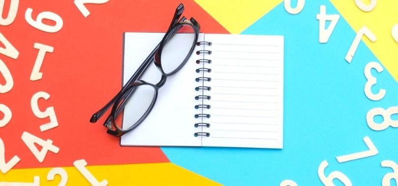 A pair of glasses sitting on top of a journal.