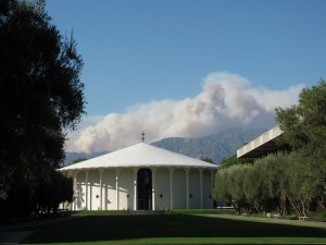 White chapel building on the CalTech campus with a backdrop of mountains.