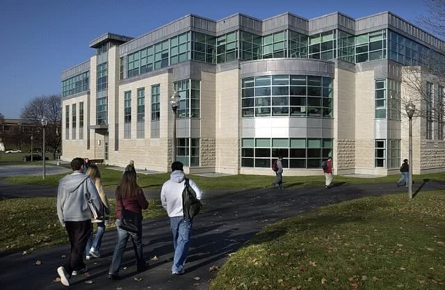 Four students walking towards the campus.