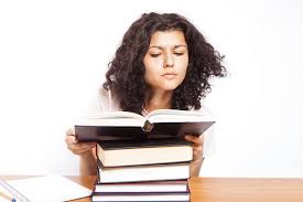 A college girl reads a book in the library.