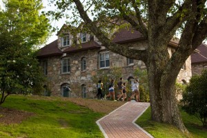 Students walking in front of a brick building on the Lees McRae college campus.