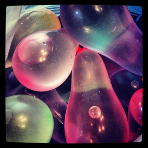Colorful water balloons on top of each other.