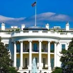 The White House behind trees and a fountain.