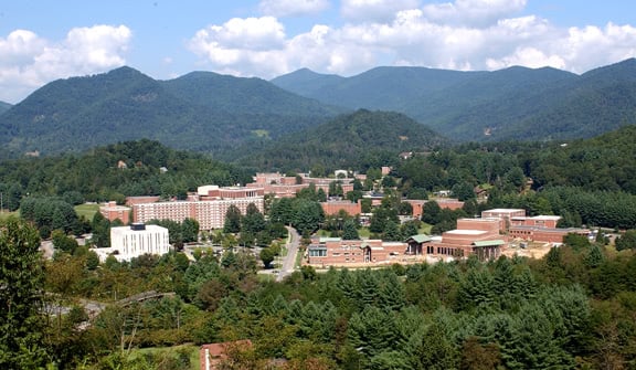 Western Carolina University campus from afar. Surrounded with trees and mountains on the background.