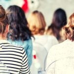 A room full of women with their backs toward the camera.