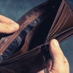 A person holding a brown empty wallet.