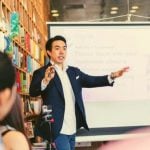 A teacher standing in front of a whiteboard.