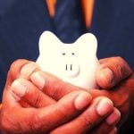 A person holding a white piggy bank in their hands.