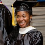 A girl graduate student is smiling and looking far away.