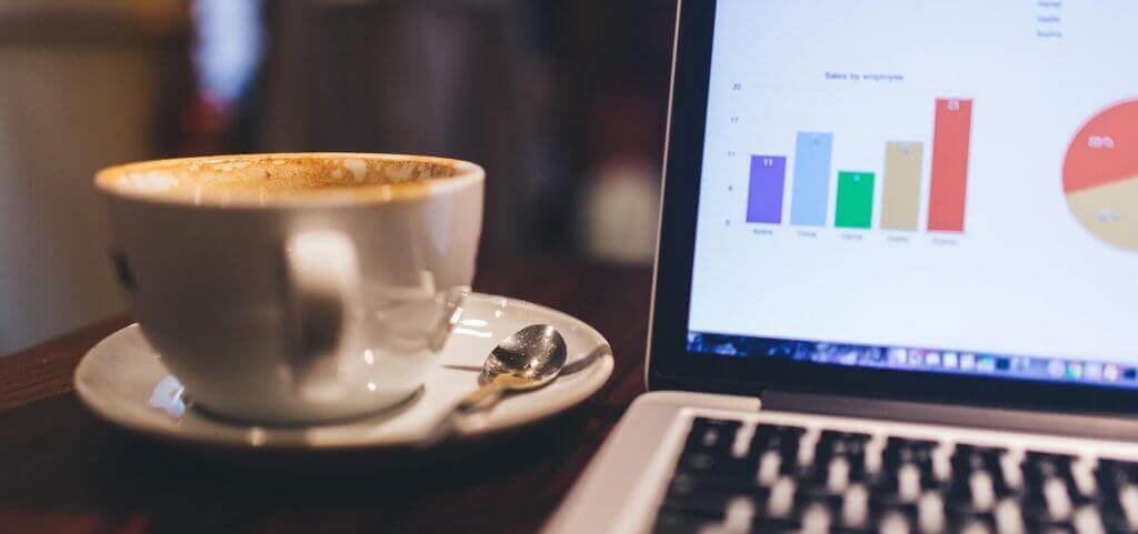 Student's coffee and laptop on a table at a campus coffee shop.