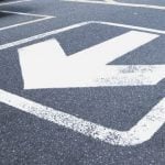 A white arrow pointing away printed on a road.