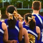 Cheerleaders in a blue uniform lined up.
