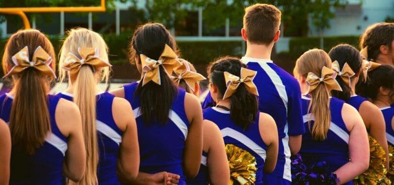 Cheerleaders in a blue uniform lined up.