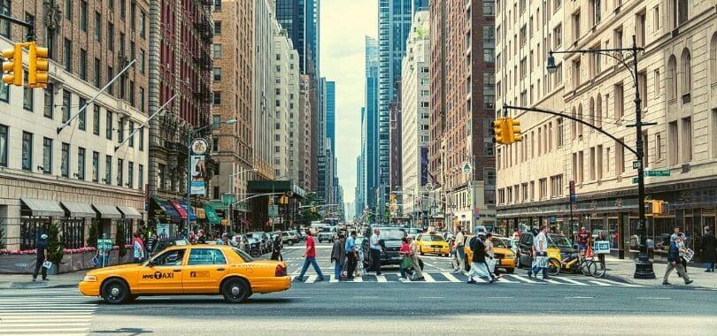 Downtown New York with people crossing a street.