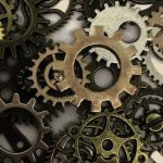 Different sizes and colors of gears in a pile.