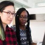 Two people sitting at a computer together.