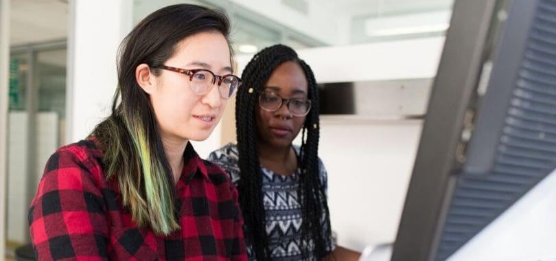 Two people sitting at a computer together.