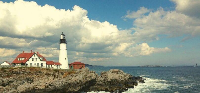 A lighthouse in Maine next to the ocean.