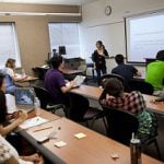 Students listening to a lecture by a professor in the classrom at UIS.