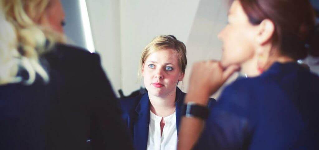 Two people interviewing a college graduate.