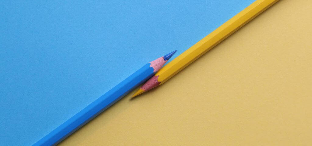 Blue and beige color pencils laying parallel to each other.