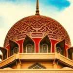 A red and gold dome of a temple.