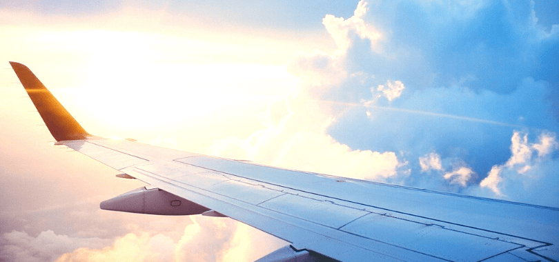 The wing of an airplane against a sunset.