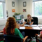 Three students meeting with their academic advisor inside her office.