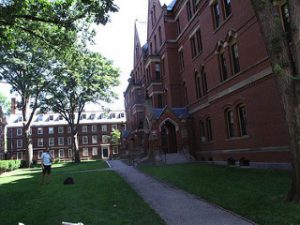 Student standing outside Harvard University red brick building.