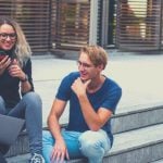 Three college students sitting on stairs.