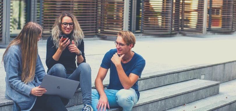 Three college students sitting on stairs.