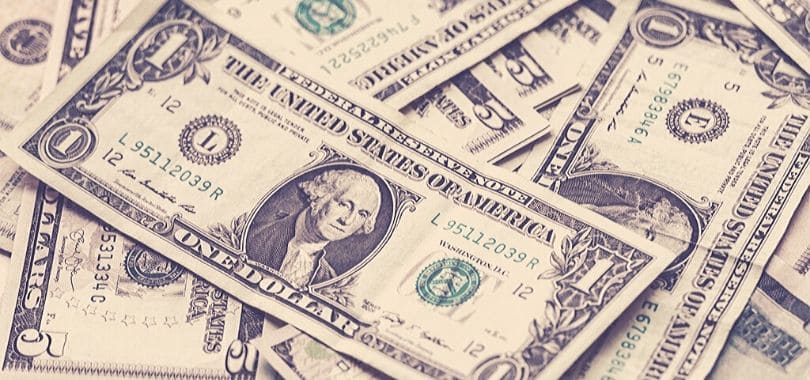 Dollar bills scattered on top of each other.