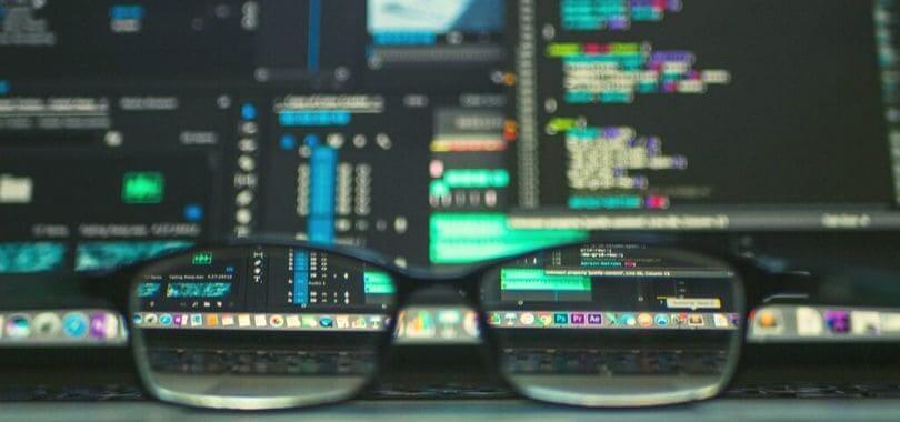 A pair of glasses resting on a laptop.