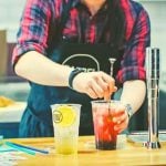 A person stirring an iced drink.