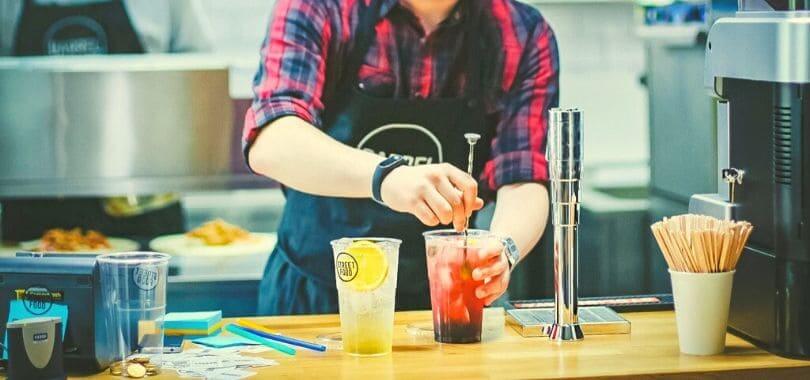A person stirring an iced drink.