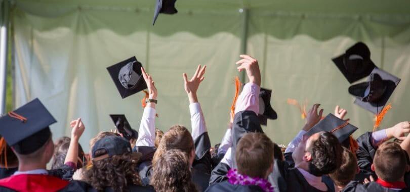 Graduating students throwing their caps in the air.