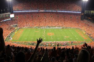 Clemson stadium with thousands of people cheering for a football game.