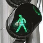 A crossing light showing a green man walking.