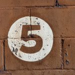 Number 5 on a brick wall.