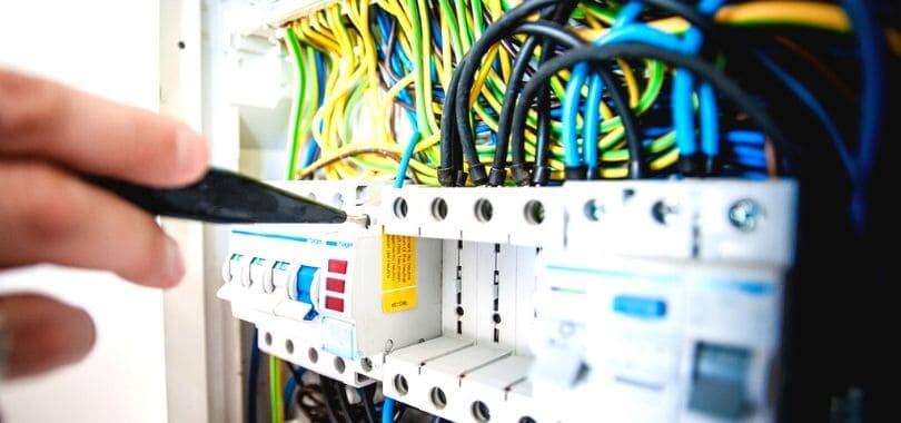 Blue, yellow, and green wires crossed in a machine.