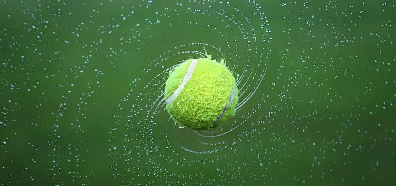 A tennis ball spinning with a darker green background.