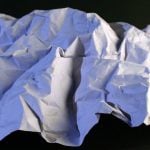 Crumpled piece of paper on a black background.