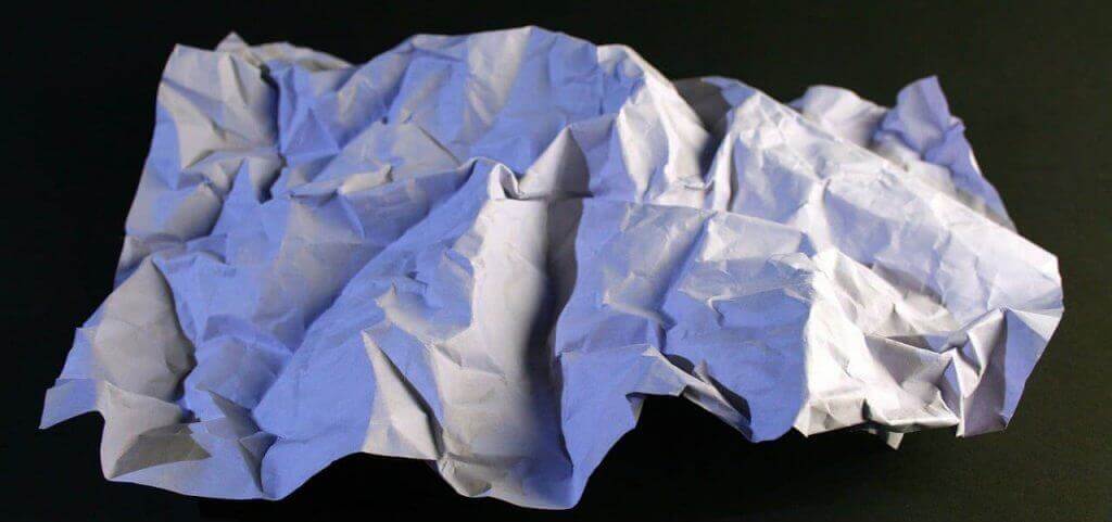 Crumpled piece of paper on a black background.