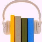 Four books held together with a pair of headphones.