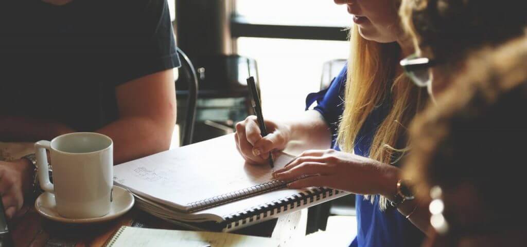 A college student writing in a notebook.